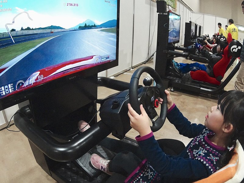 A driver locked into a sim racing cockpit rig, hands on the wheel